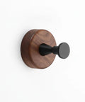 Kickass Single Wall Hook Built With Rock Solid Aluminum And Rich Black Walnut Wood For Hanging Heavy Winter Coats Bath Towels Backpacks And Daily Essentials In Entryways Or Bathrooms mounted on a white wall.