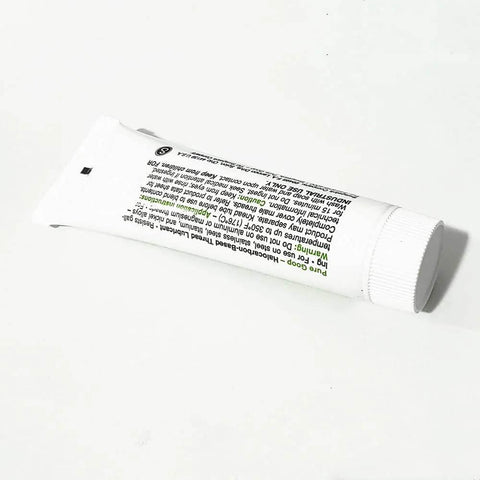 Side view of white plastic squeeze tube labeled Pure Goop waterjet spare parts, ribbed screw-cap, Amazon brand.