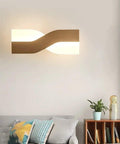UPRENXIAO Modern Minimalist Nordic Led Wall Sconce Wavy Twisted Design Baked illuminating a living room with soft light.