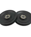 Two black smooth finish Beefy Nylon Bearing Pulley Wheels with 112.5mm outer diameter for cable machines, weightlifting systems.