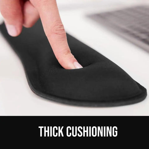 Close-up of finger pressing Silky Memory Foam Wrist Rest For Keyboard And Mouse Ergonomic Design For Typing Pain Relief Two Piece Desk Pad Set Stain Resistant Black Crazy Comfy Fits Most Desks showing thickness.