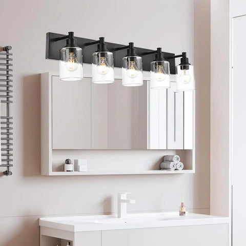 Slick Brushed Nickel 4 Light Bathroom Vanity Lights with clear glass shades over a mirror in a modern powder room.