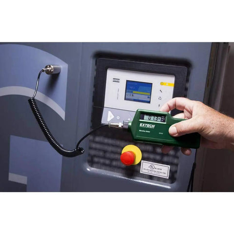 Top Tier Vibration Analyzer With Built In Laser Tachometer measuring acceleration, velocity near a control panel.