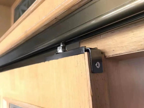 Close-up of Built Rock Solid Two Door Barn Track System Bronze Aluminum Sliding Door Hardware Kit showing ceiling mount and roller details.