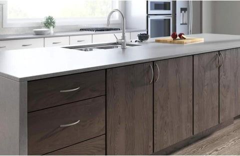 Kitchen island with transitional tapered curved arch drawer handle pull in satin nickel finish 128mm center to center on dark wood cabinets.