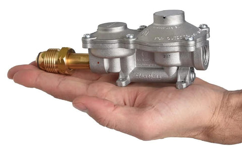 Flame King 2-stage propane regulator with POL, silver body and brass connector held in hand