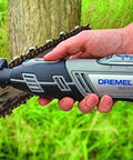 Dremel rotary tool sharpening a chainsaw chain, side view with tool beside bar and chain.