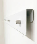 Close-up of White Magnetic Wall Display Bars For Kid Art And Photos Strong Magnet Gallery Track System with steel rail.