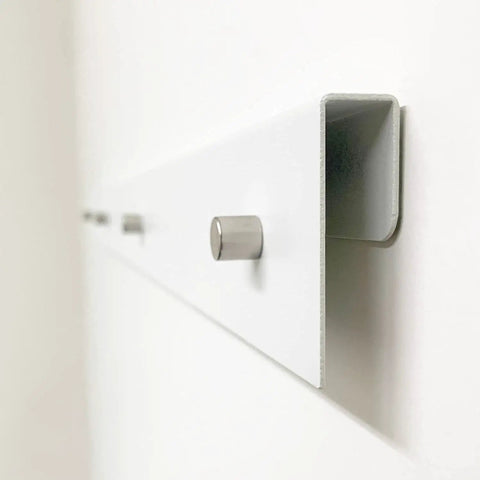 Close-up of White Magnetic Wall Display Bars For Kid Art And Photos Strong Magnet Gallery Track System with steel rail.