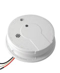 Rock Solid Hardwired Smoke Detector With Whole Home Interconnect Readiness And Dependable Backup Power For Straight Talk Fire Safety Plus Nailed Down Installation And Snappy Hush Response mounted on a wall with wires visible.