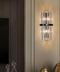 Top Shelf Crystal Wall Sconces With Brushed Black Metal And Sleek Bedroom Vanity Light For Bathroom Fixture Modern Bedside Lamp For Dining Room Decor Heavy Duty Build With Fresh Vibes mounted on beige wall beside gold decor.  