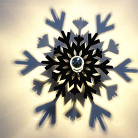 Decorative wall sculpture shaped like a snowflake, casting intricate shadows on a warm illuminated background.