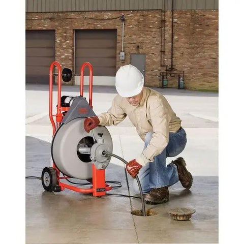 Heavy Hitter Auto Feed Drum Drain Snake Machine With 3 4 Inch C 100 Inner Core Cable in use, clearing a drain blockage.