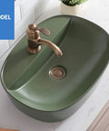 Rock Solid Black Ceramic Bathroom Sink With Square Above Counter Setup Featuring A Super Smooth Matte Glaze Finish Built Tough For Daily Washdowns And Absolute Zero Hassle Cleaning Tailored For Modern Households, showing green vessel sink with bronze faucet.