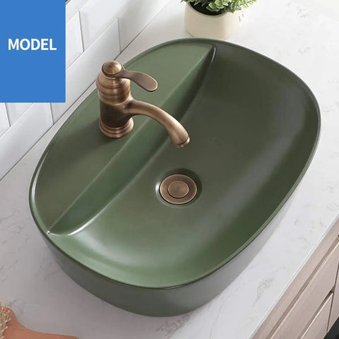 Rock Solid Black Ceramic Bathroom Sink With Square Above Counter Setup Featuring A Super Smooth Matte Glaze Finish Built Tough For Daily Washdowns And Absolute Zero Hassle Cleaning Tailored For Modern Households, showing green vessel sink with bronze faucet.