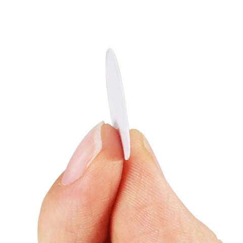 Person holding a white PVC screw hole cover, part of the Fifty Four Pack 21 Mm Self Adhesive Screw Hole Covers White Pvc Dustproof Caps For Wood Furniture Cabinet And Wardrobe Quick Slap On Fix For A Dope Game Changing Home Decor Touch.
