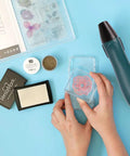 Compact Mini Hot Air Gun For DIY Pros Two Temperature Settings 662F High And 482F Low With Silicone Brush Kit visible next to embossing supplies