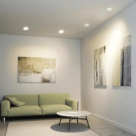 Narrow Frame LED Recessed Downlight illuminating a modern living room with green sofa and abstract wall art.