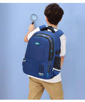 Boy with durable waterproof rolling backpack for boys ideal for elementary and middle school, blue design, side view.