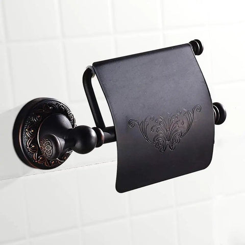 Oil Rubbed Bronze Toilet Paper Holder With Cover, brass tissue roll holder with floral design, mounted on tiled bathroom wall.