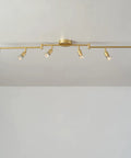 Payton 6-Light Foldable Track Lighting in Painted Brass with Exposed Sockets installed on a ceiling showcasing minimalist style.
