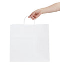 Sturdy White Paper Shopping Bags With Handles 14.2 By 8.3 By 13.2 Inches 100 Pack Durable Grocery Gift Bags being held by a hand