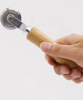Hand holding Precise 0.5mm Cardboard Scoring Tool with durable metal wheel and oak handle, ergonomic 6.3 inch DIY tool