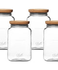 Set of four stackable square glass mason jars with solid acacia wood lids for pantry storage.