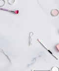 Heavy Duty Stainless Steel Cotter Pins With Wavy Design Secure Industrial Hitch Connections And Mechanical Fasteners That Never Slack Or Fail For Serious Projects on marble surface with makeup tools.