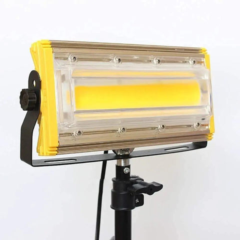JUDYSSY Led Floodlight 50W 3600Lm Led Outdoor Floodlight mounted on a tripod with a yellow and clear casing.
