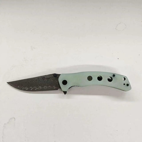 Damascus Pocket Folding Knife With 3.26 Inch Sharp Blade And G10 Handle, side view on white background.