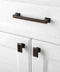 10 Pack 5 Inch Cabinet Pulls In Oil Rubbed Bronze installed on white kitchen cabinets showing elegant finish.