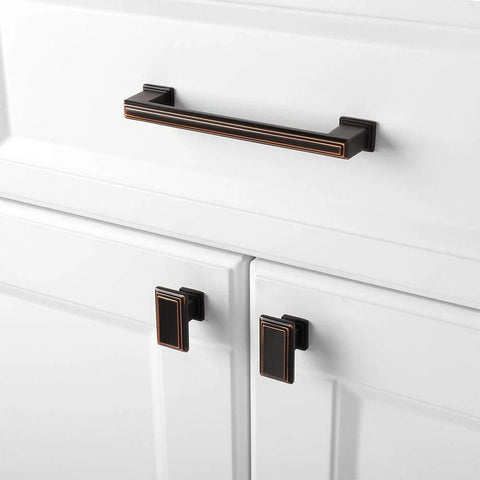 10 Pack 5 Inch Cabinet Pulls In Oil Rubbed Bronze installed on white kitchen cabinets showing elegant finish.