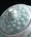 Close-up of the lid knob of Airtight Ceramic Coffee Canister Porcelain Tea Caddy With Tight Seal Lid Keeps Your Stash Fresh As A Dime For Kitchen Pantry Organization Blue Jar.