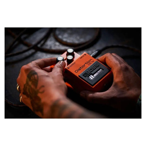 Hands adjusting DS-1W Special Edition Waza Craft Distortion Pedal With Two Modes Delivers Classic Crunch And Modern Sizzle.