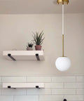 Globe Pendant Light With Matte White Glass And Brass Finish, Dope Modern Mid Century Ceiling Fixture in a minimalist kitchen