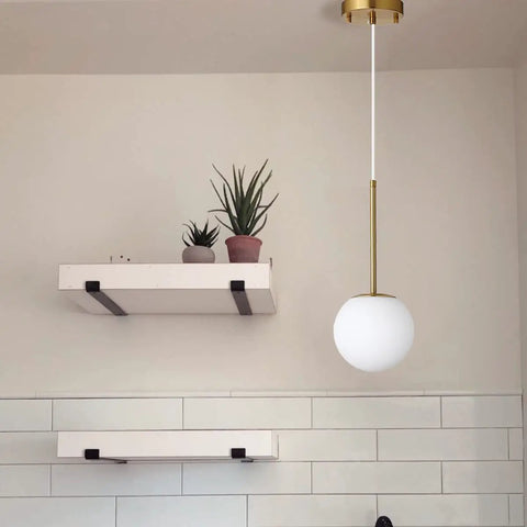 Globe Pendant Light With Matte White Glass And Brass Finish, Dope Modern Mid Century Ceiling Fixture in a minimalist kitchen