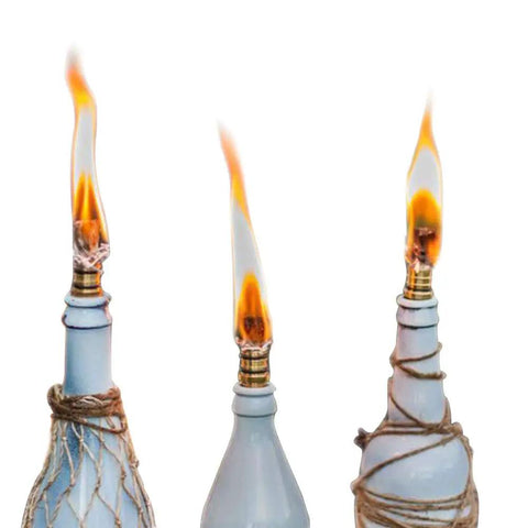 Three lit wine bottle torch kit with long life fiberglass wicks, brass wick holders, and brass caps for outdoor garden lighting.