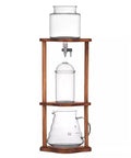 Artisan Glass Cold Brew Coffee And Tea Dripper With Adjustable Flow Knob And Walnut Base on display, showcasing brewing components.