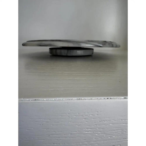 Side view of 11.75 Inch Marble Lazy Susan Turntable With Vintage Gray Stone Finish, showcasing its sleek design and smooth base.
