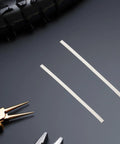 Two white polypropylene welding rods on a dark surface, part of Forty Pieces White Pp Plastic Welding Rods For Car Bumper Repair Kit.