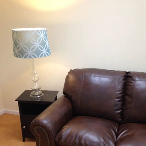 Living room setting with lamp beside brown leather sofa