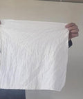 Person holding a Medical Grade White Cleaning Rag Lint Free Industrial Shop Towel for Mechanics and Painting.