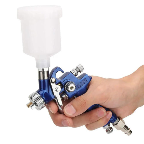 Top Tier Hvlp Gravity Feed Spray Gun Precision Zero Point Eight Millimeter Tip Tough Aluminum Body held in hand with gravity cup.