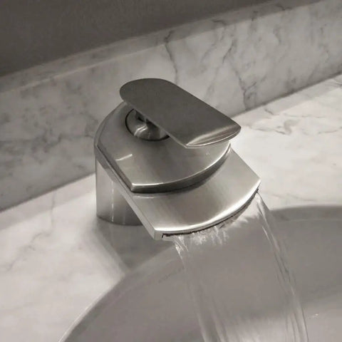 Wave Single Lever Waterfall Lav Faucet in Brushed Nickel, solid brass build, installed on marble sink deck, water flowing