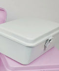 Heavy Duty Vintage White Metal Toolbox Featuring A Tight Snap Shut Locking Latch Tin Storage Case on a pink surface.