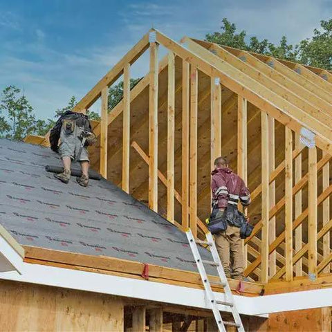 Two contractors installing Heavy Duty Synthetic Roof Underlayment Waterproof Felt Alternative on a pitched roof frame.