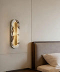 Modern Minimalist Long Marble Wall Sconce Nordic Alabaster Wall Mount Light Fixture illuminating a bedroom wall near a bed.