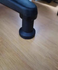 Close-up of a black bell glide from the 5 Pack Top Shelf Bell Glides For Office Chairs And Desk Stools on hardwood floor.