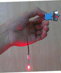 Hand holding Portable Mini Wind And Hydro Generator Dual Powered Educational Kit with LED lit, showing plastic turbine component.
